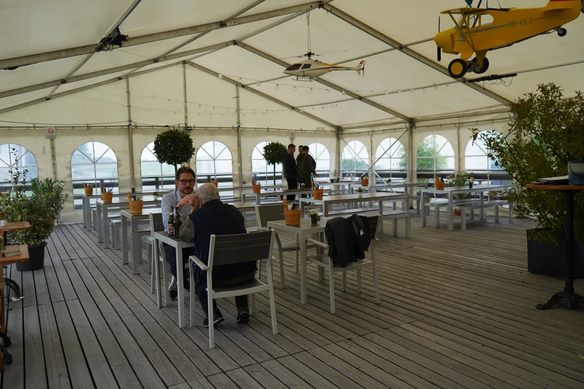 Ein Festzelt und Gäste, die miteinander sprechen.